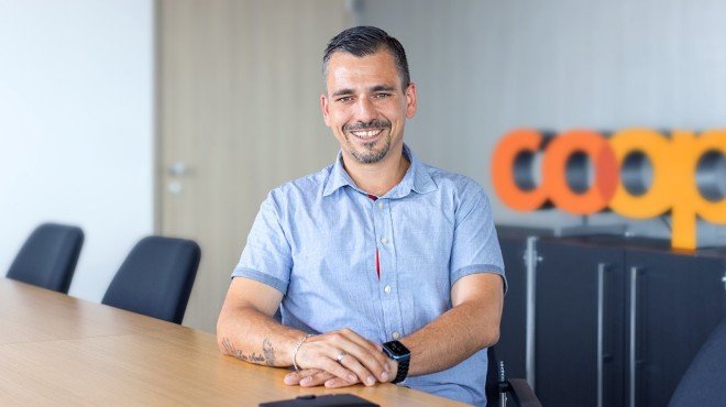 Ein Chaffeur in einem Lagerhaus lächelt in die Kamera.