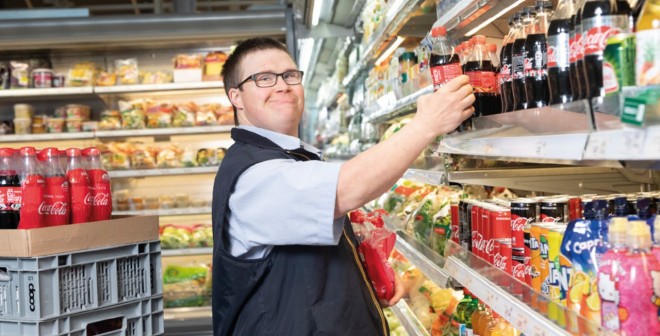 Ein Mitarbeitender des Projekts «Job Integration» vor einem Getränkeregal 